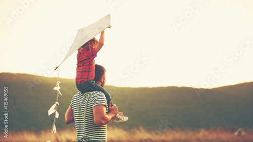 happy family father and child on meadow with a kite in summer photo