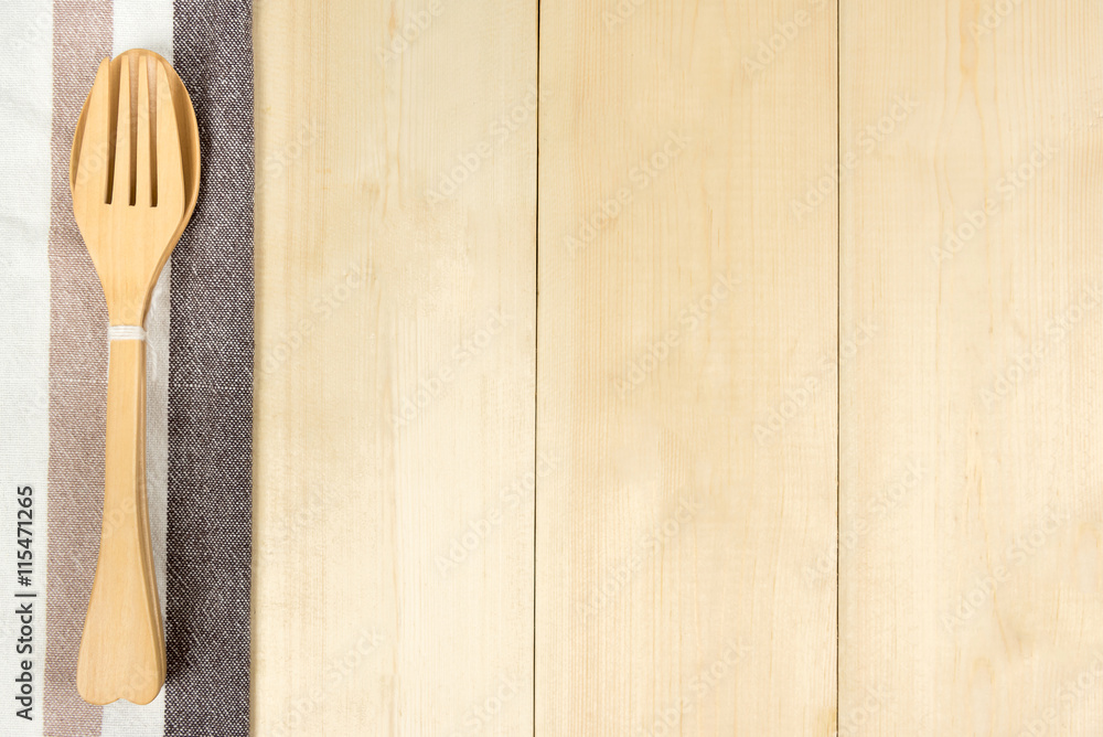Top view of wooden spoon and fork with napkin on wooden table with copyspace. Top view of wooden spoon and fork with napkin on wooden table with copyspace.