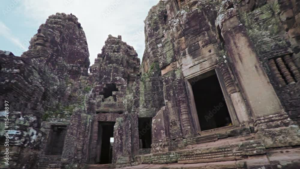 Panning shot reveals ancient, intricately carved and lichen covered walls of Bayon Temple near Angkor Thom in Cambodia. Video 4k Panning shot reveals ancient, intricately carved and lichen covered walls of Bayon Temple near Angkor Thom in Cambodia. Video 4k