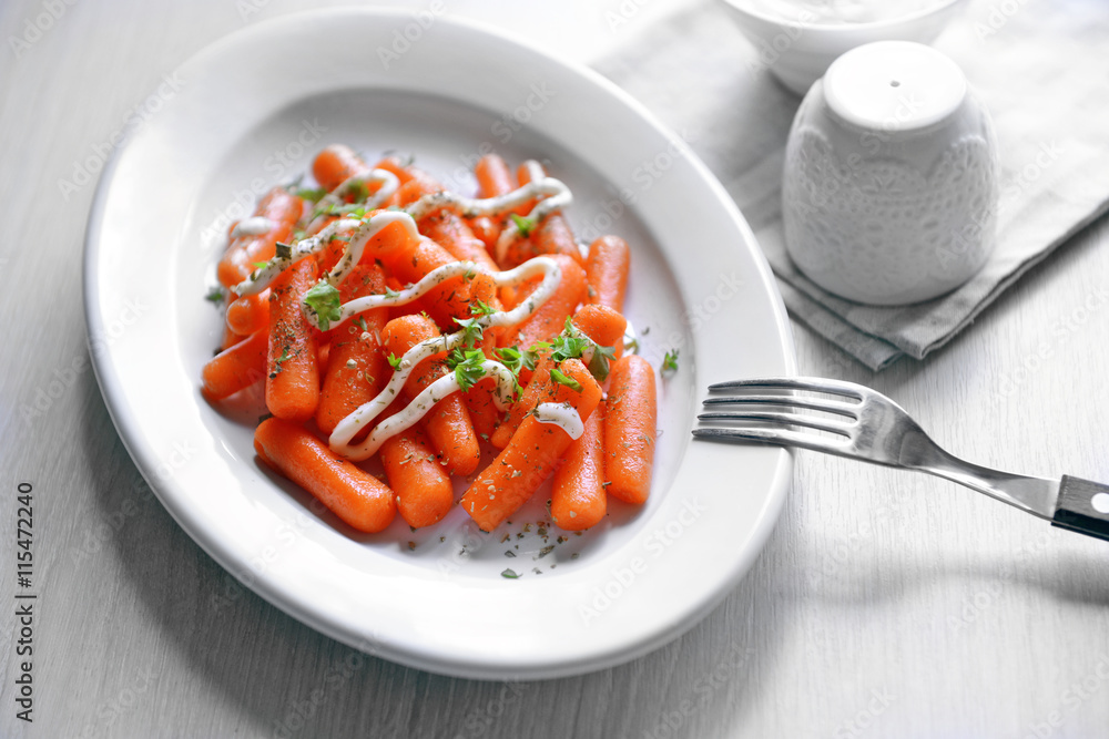 Baby carrot with greens and mayonnaise on plate closeup Baby carrot with greens and mayonnaise on plate closeup