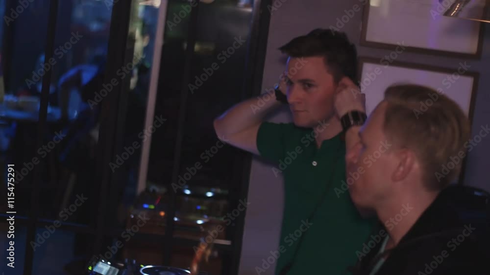 Dj spinning at lighted turntable. Man with saxophone dance. Party in nightclub. Music Dj spinning at lighted turntable. Man with saxophone dance. Party in nightclub. Music