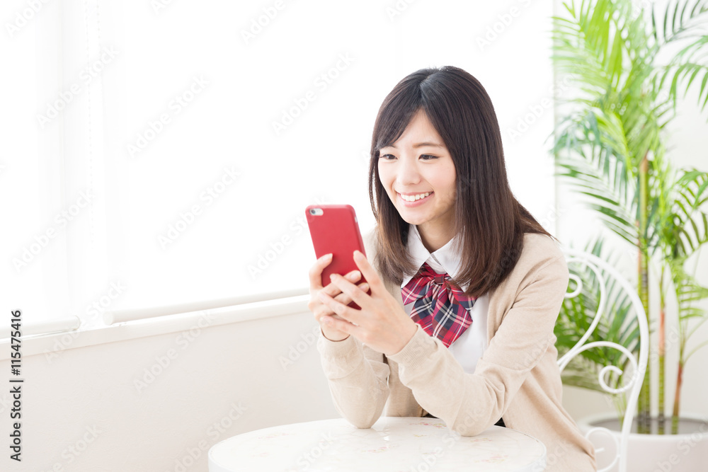 asian schoolgirl using smart phone in the cafe asian schoolgirl using smart phone in the cafe