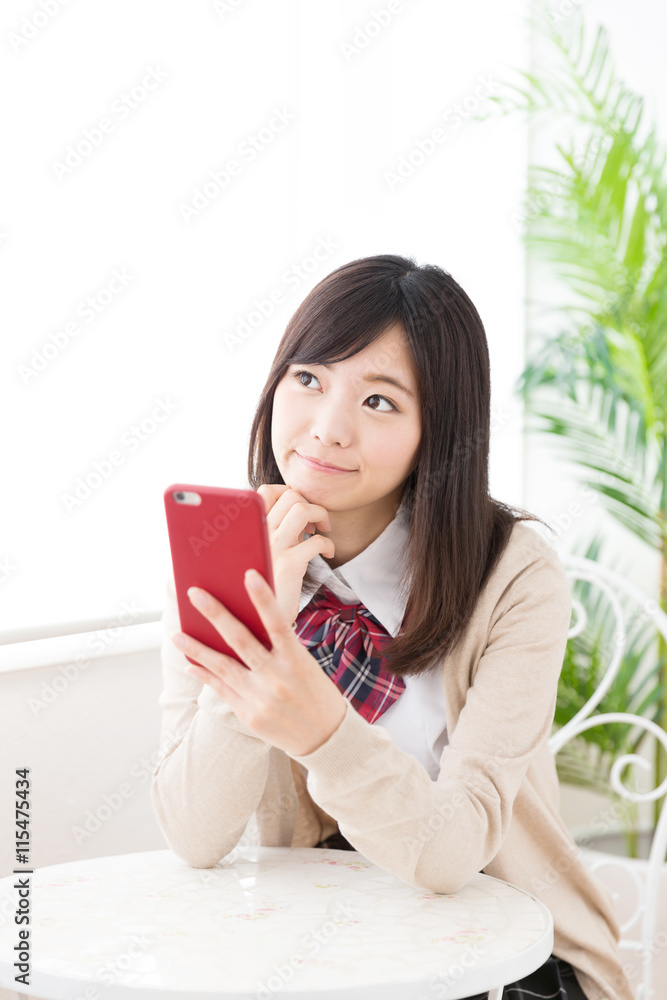 asian schoolgirl using smart phone in the cafe asian schoolgirl using smart phone in the cafe