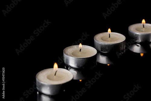 Lit Tea Candles with Reflection on Black