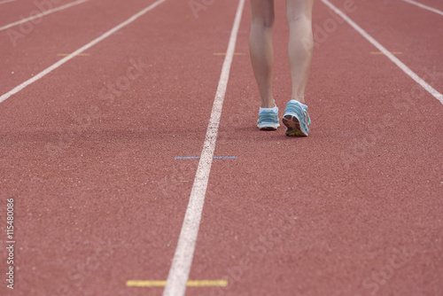 Young woman running on racetrack during training session. Asian