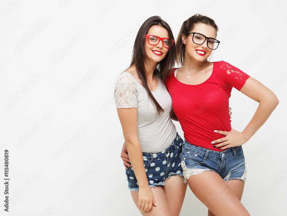 Two young girl friends standing together and having fun. Two young girl friends standing together and having fun.