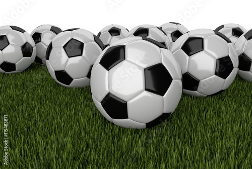 many soccer balls on grass