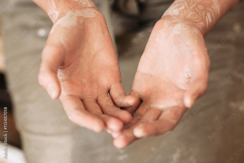 Potter messy palms in clay, working hands of craftsman. Closeup Potter messy palms in clay, working hands of craftsman. Closeup