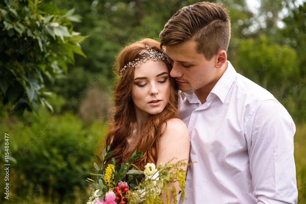 Elegant bride and groom posing together outdoors on a wedding day. bride and redhead groom in wheat ears in the Park Elegant bride and groom posing together outdoors on a wedding day. bride and redhead groom in wheat ears in the Park