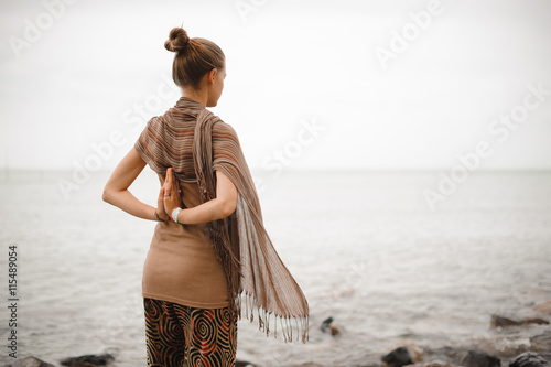 Yoga nature spa. The back of a beautiful woman with her hands in namaste. photo