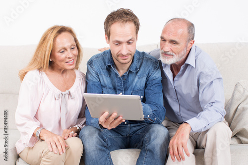 Three persons looking at a tablet