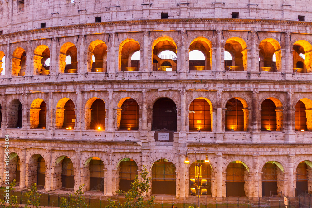 view of Colosseum facade close up illuminated at night in Rome, Italy