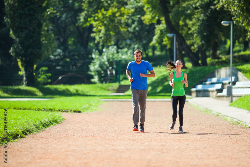 Young couple is jogging on sunny day.