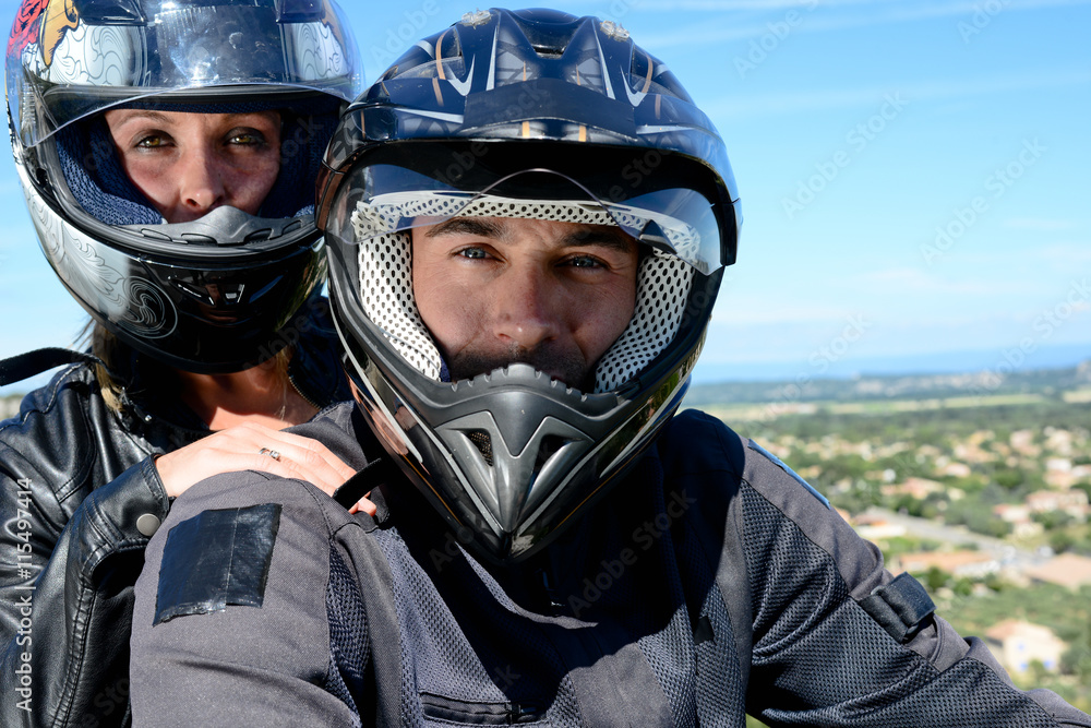 happy young biker couple riding their motorbike in summer happy young biker couple riding their motorbike in summer