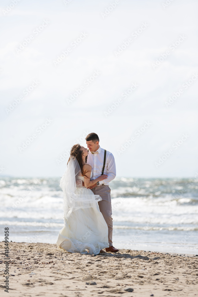 Cheerful wedding couple on the beach