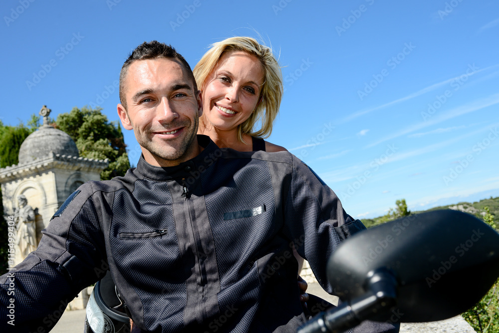 happy young biker couple riding their motorbike in summer happy young biker couple riding their motorbike in summer