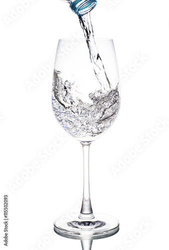Water is poured in a glass wine transparent white background.