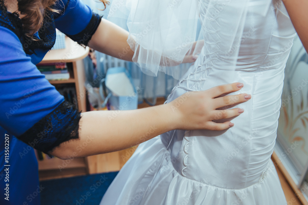 bridesmaids help dress bride gown. bridesmaids help dress bride gown.