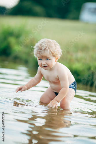Fototapeta Naklejka Na Ścianę i Meble -  little funny boy playing in water