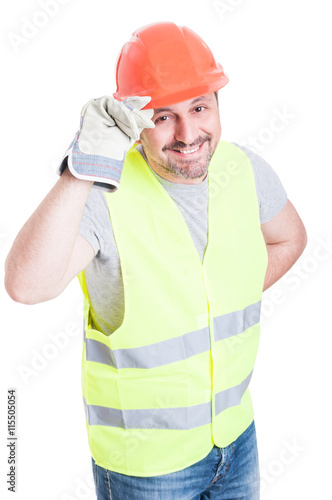 Attractive builder man holding helmet acting polite