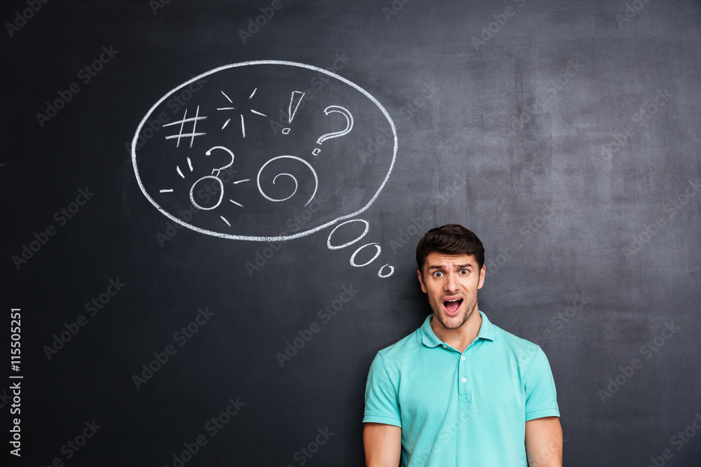 Confused man thinking about problem with blackboard behind him