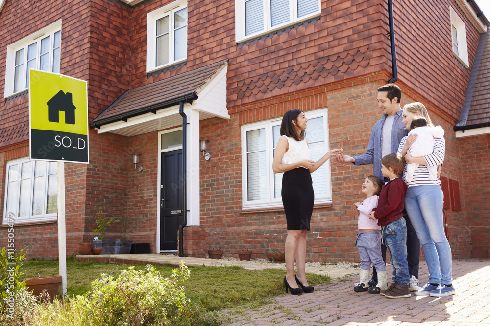 Young Family Collecting Keys To New Home From Realtor