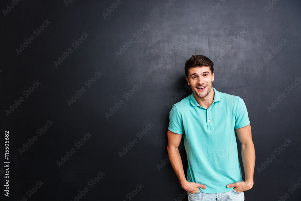 Handsome young man looking at camera over black background Handsome young man looking at camera over black background