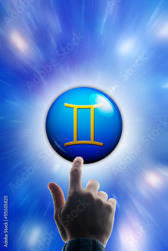 hand touching a button with the zodiac symbol of Gemini