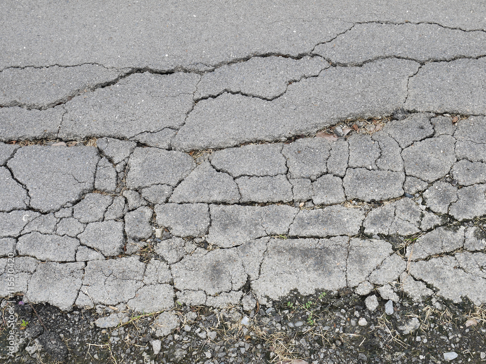 Obraz premium Old worn and cracked asphalt with cracks