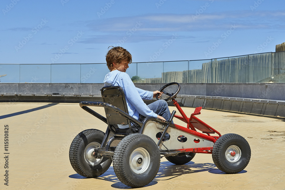 Young boy driving a Quadricycle Young boy driving a Quadricycle