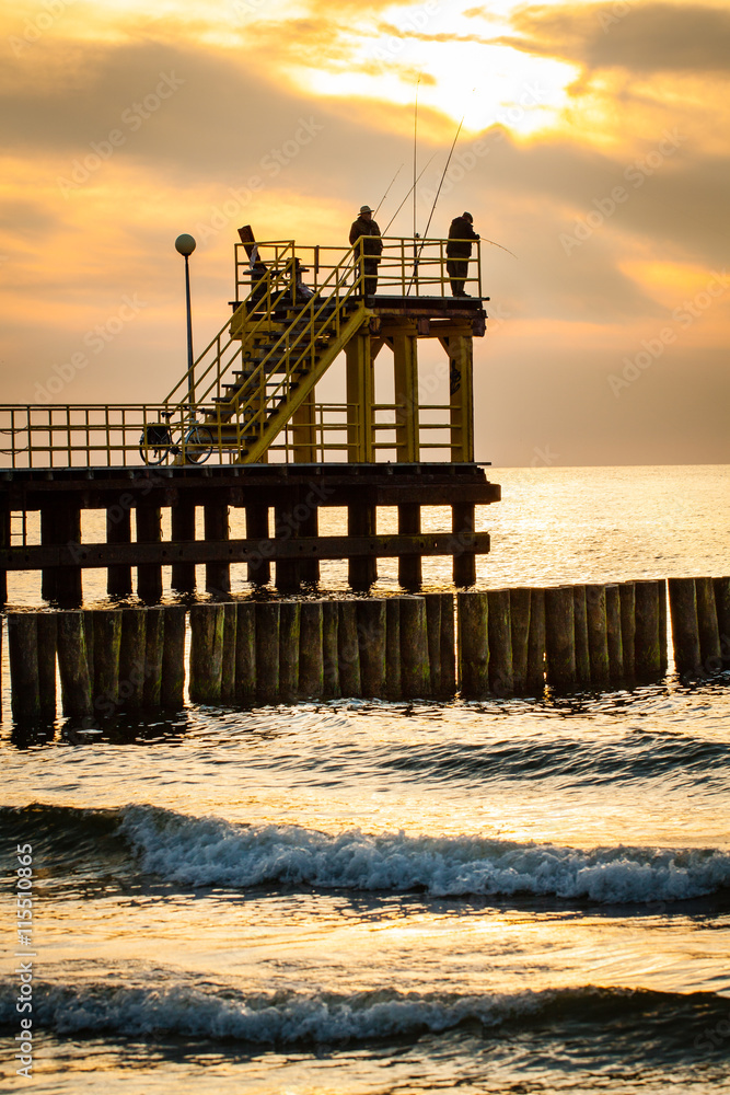 Coastal pier with silhouettes of anglers during sunset. Baltic, Poland. Coastal pier with silhouettes of anglers during sunset. Baltic, Poland.