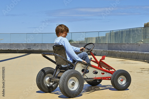 Young boy driving a Quadricycle