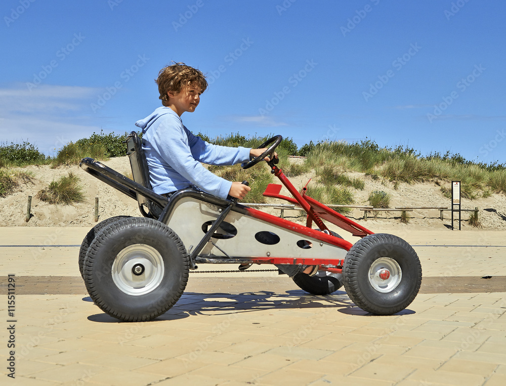 Young boy driving a Quadricycle Young boy driving a Quadricycle