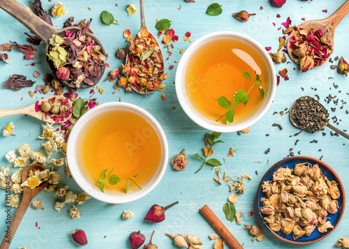 Fototapeta Two cups of healthy herbal tea with mint, cinnamon, dried rose and camomile flow