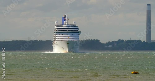 Ocean liner cruise ship with sailing boats manouvring outside Southampton port in England photo