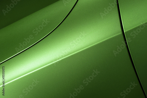 Surface of green sport sedan car, detail of metal hood, fender and door of vehicle bodywork 