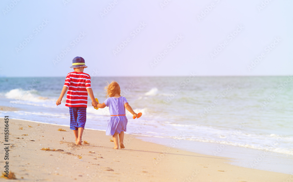 little boy and girl walking on beach