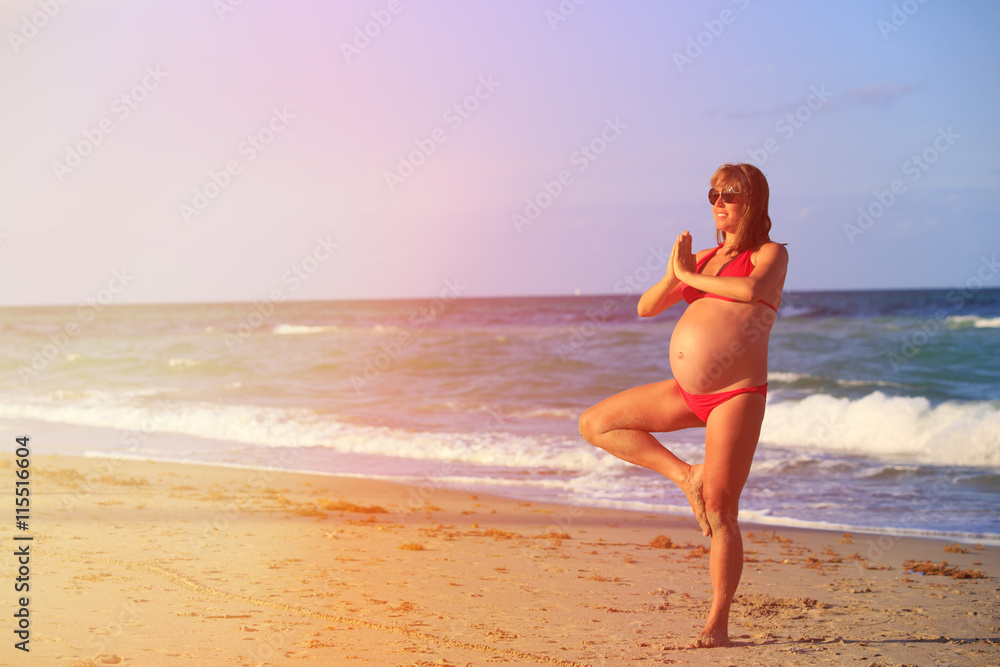 Pregnant woman practicing yoga at beach
