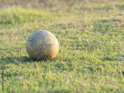 Old used Soccer ball on the green grass field