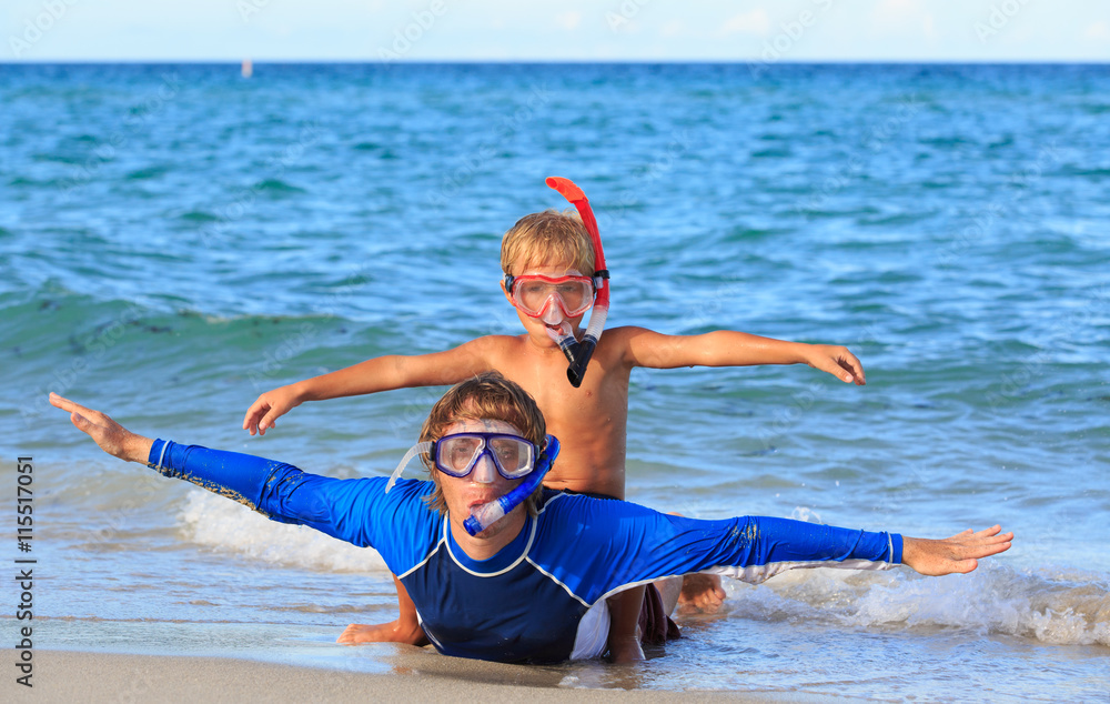 happy father and son snorkeling on beach