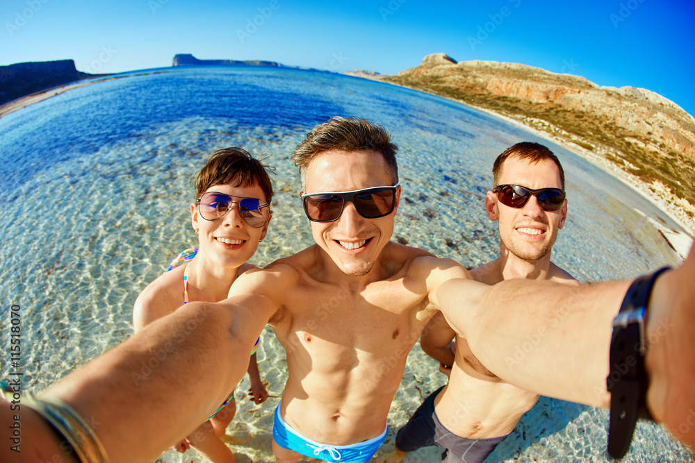 young happy couple friends on the beach taking selfie on sea background. Balos beach, Crete, Greece. young happy couple friends on the beach taking selfie on sea background. Balos beach, Crete, Greece.