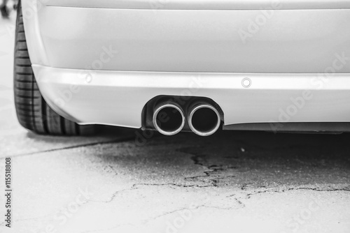Double exhaust pipes of a modern sports car, black and white