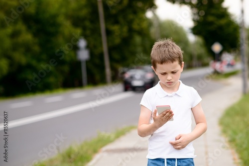 child playing mobile games on smartphone on the street
