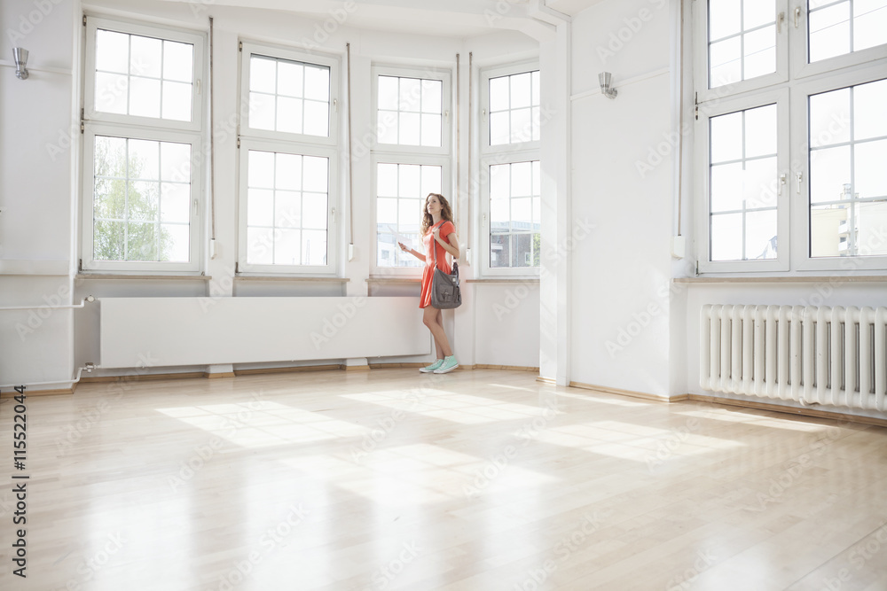 Woman looking around in empty apartment Woman looking around in empty apartment