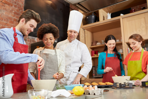 happy friends and chef cook baking in kitchen