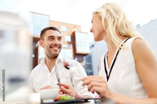 happy couple eating dinner at restaurant terrace