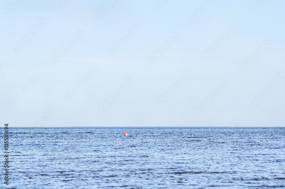 calm sea landscape with a lone red buoy in the distance and the fishermen on the boat