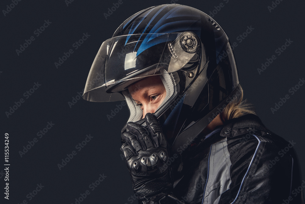 Female in motorcycle safety costume and black helmet.
