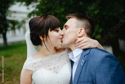 Bride and groom at wedding Day walking Outdoors on summer nature. Bridal couple, Happy Newlywed woman and man embracing. Loving wedding couple outdoor.