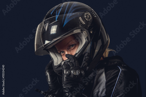 Female in motorcycle safety costume and black helmet. © Fxquadro